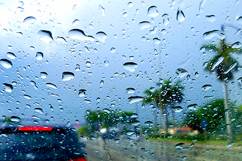 This is a stock photo. An up close image of raindrops on a car window.